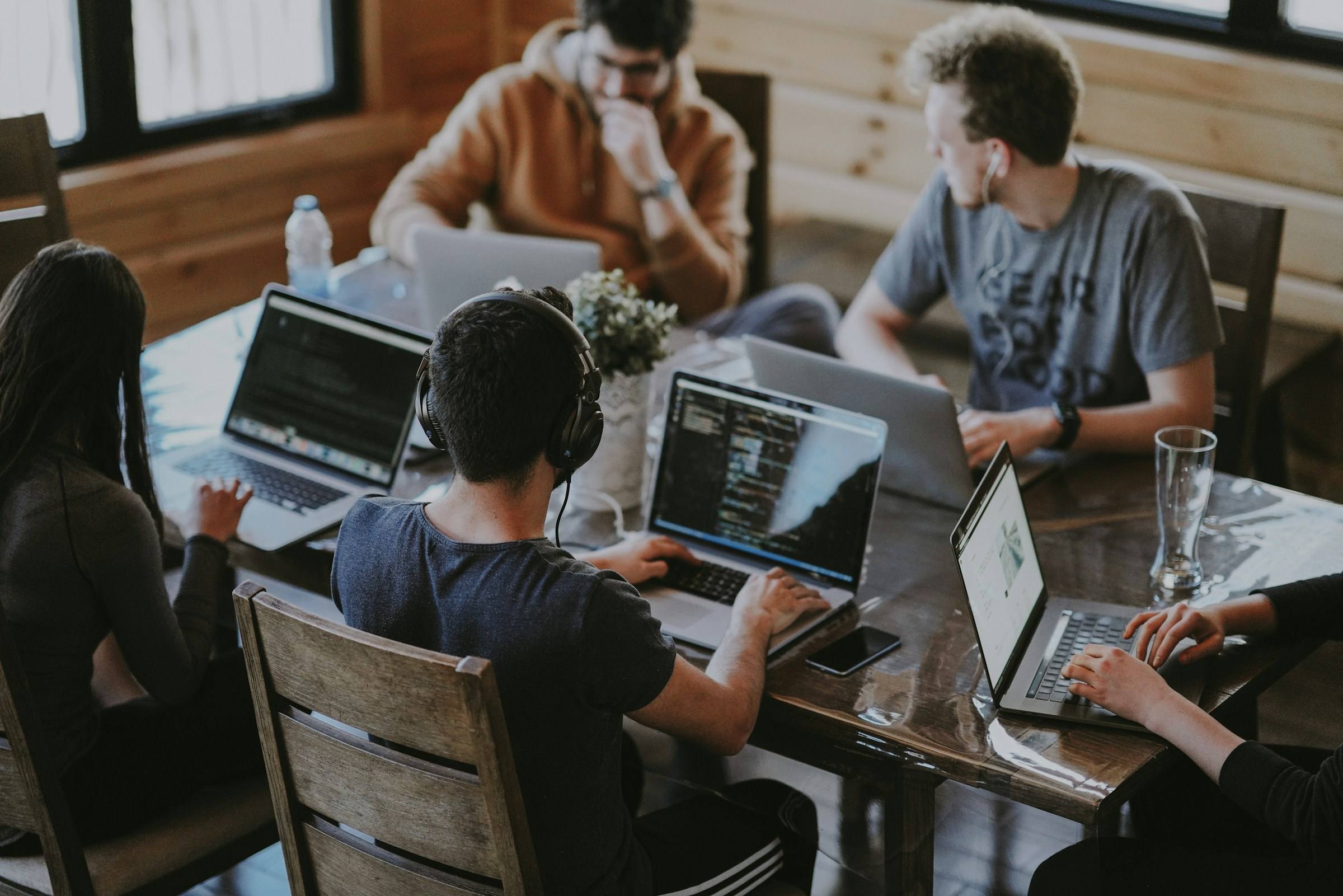 A small engineering team working together on laptops around one table